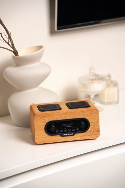 Stylowe, brązowe radio Blaupunkt DR10CR odtwarzające muzykę w domowym wnętrzu.