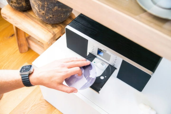 Wbudowany odtwarzacz płyt CD z wygodną szufladą w systemie All-in-One marki JVC.